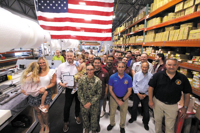 CELEBRATING THE HONOR: Palmer Industry employees paused production as U.S. Navy Petty Officer Second Class Sianna McNulty, whose husband Shane works at the plant arranged to have Shane present company owner and CEO Jeff Nelson  with a Patriot Award. The presentation coincided with an employee appreciation luncheon Nelson held for Palmer employees. (Warwick Beacon photo)