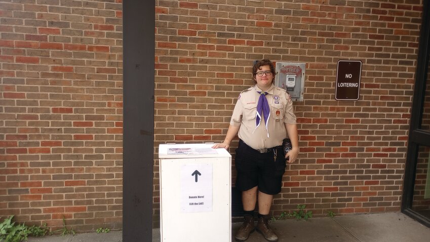 EAGLE INCOMING: Soon to be Eagle Scout Robert Bitgood stands outside of Central Library with one of the collection boxes he built with the help of his troop mates to complete his Eagle project. (Herald photo by Ed Kdonian)