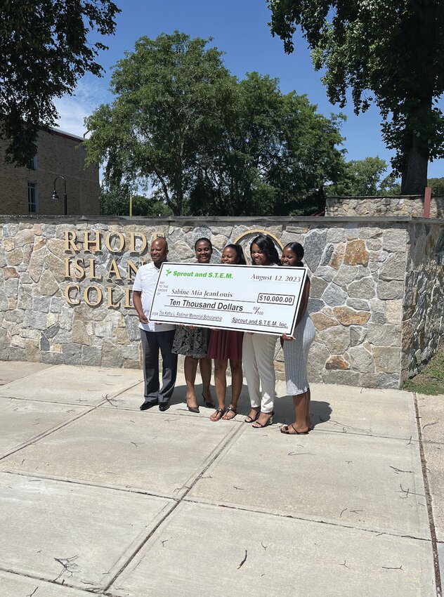 Picking up the check: Sabine Mia JeanLouis (second from right) smiles with her giant check as she celebrates with her father, mother and sisters. (Submitted photo)