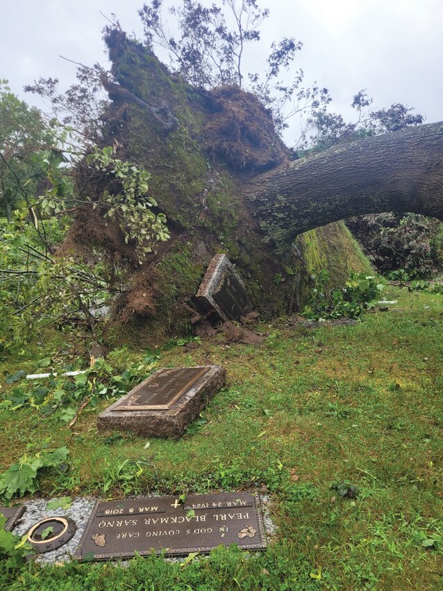 DIRECT HIT: Highland Memorial Park Cemetery in Johnston seems to have taken a direct hit by Friday morning's tornado. A path of destruction: fallen trees, scattered planters, grave markers dislodged and huge trees toppled. (Beacon  photo by Rory Schuler)