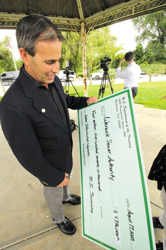 A BOOSTER TO RATEPAYERS: Mayor Picozzi with a super-sized check representing the federal grants funds the city will receive. The money will reduce the dependence on ratepayer funding to upgrade the sewer system. (Warwick Beacon photo)