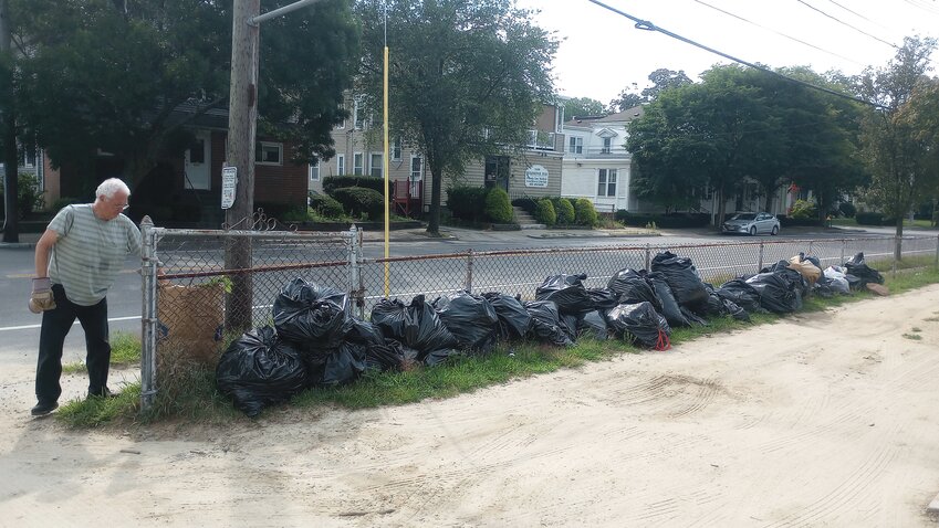 THEY JUST KEEP COMING: This is just an example of the recent trash and yard waste that is being continually cleaned up by volunteers at Oakland Cemetery. Paul Tognetti of the City&rsquo;s Cemeteries Comission adds another bag of yard waste to the growing pile. (Herald photos by Ed Kdonian)