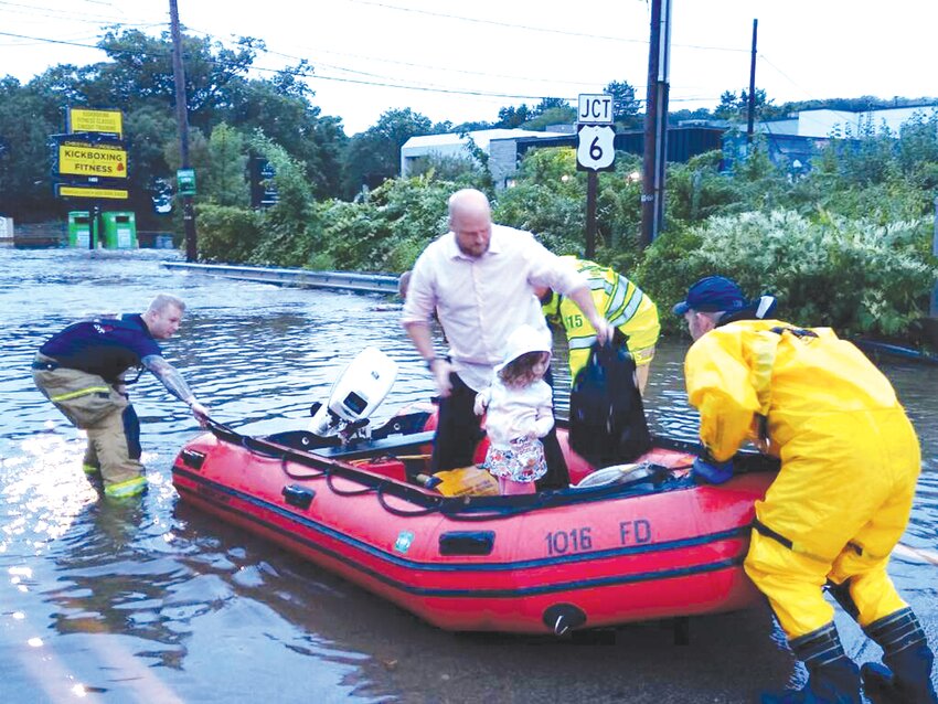 ATWOOD RIVER: A family was rescued by firefighters in a boat from their stuck vehicle in the middle of Atwood Avenue during Monday night&rsquo;s widespread flooding in Johnston. (Photo courtesy Mike Edwards)