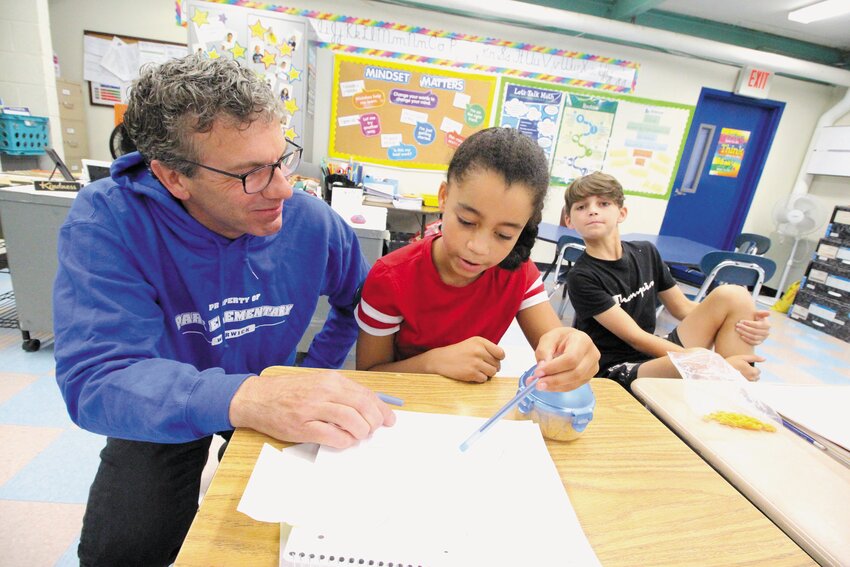 CRUNCHING THE NUMBERS: Park Elementary School principal Daniel Sylvestre talks through long division with fifth-grader Ava Barrole, as fellow fifth-grader Camden Dickson looks on.