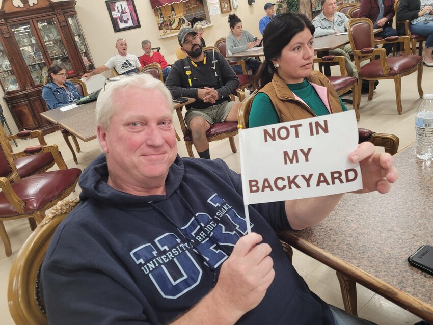 SIGNS OF THE TIMES: Residents held tiny flags decrying &ldquo;Not In My Backyard&rdquo; and urging the board to &ldquo;Protect Our Trees and Wildlife.&rdquo; (Herald photos by Rory Schuler)