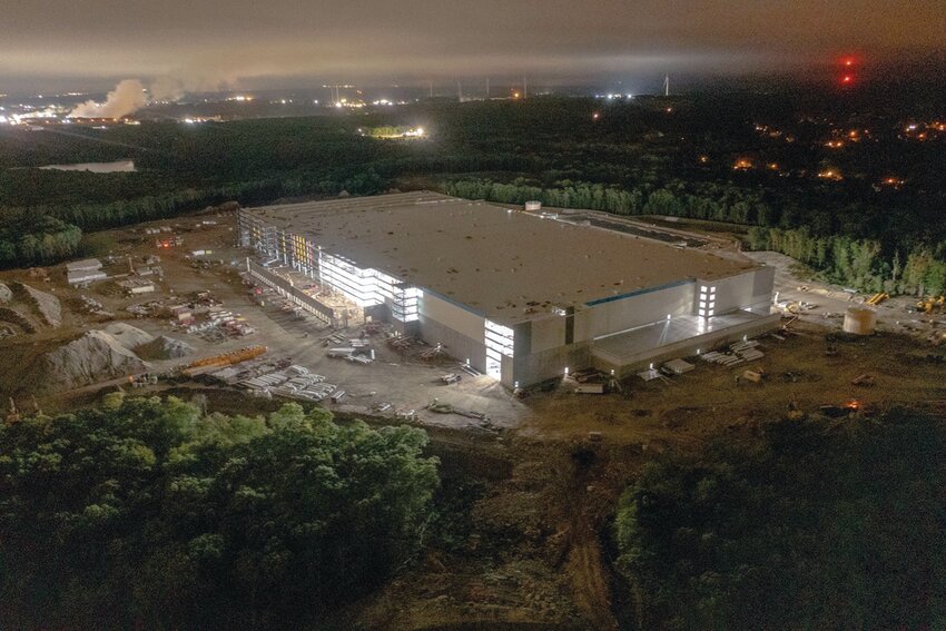 PACKAGE DELAYED: These images of the Amazon construction site in Johnston, following the sunset, were captured by a drone piloted by Trevor Bryan, an FAA Licensed and insured drone pilot, the owner and operator of New England Aerial Services, on Sept. 21, 2022. The illuminated project has been taking shape on the Hartford Avenue hill overlooking Johnston, but its opening date has been pushed to late 2024.