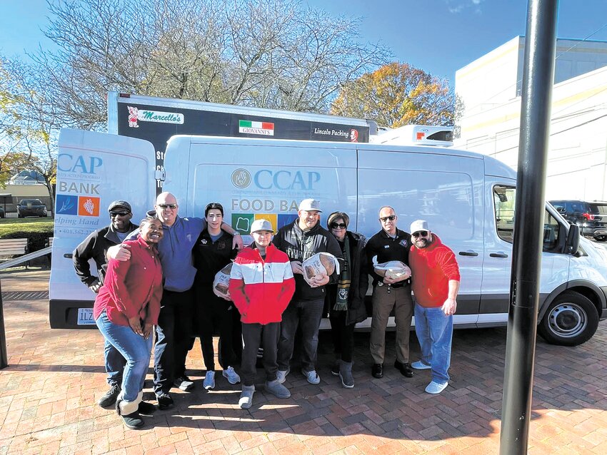 ALL FOR CRANSTON: Members of the Cranston Cares board, Cranston Police Officers, and representatives from CCAP take a moment to celebrate the donation of 200 turkeys. (Herald photos by Pam Schiff)