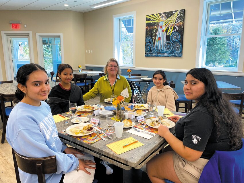 THANKFUL FOR EACH OTHER: Lissa Scarpellino (center) enjoys some turkey and sides with (L-R) students Eymy Urizar, Shaylin Ramirez, Sheyli Urizar and Yara Alkassem. (Photo courtesy of Karen Farley)