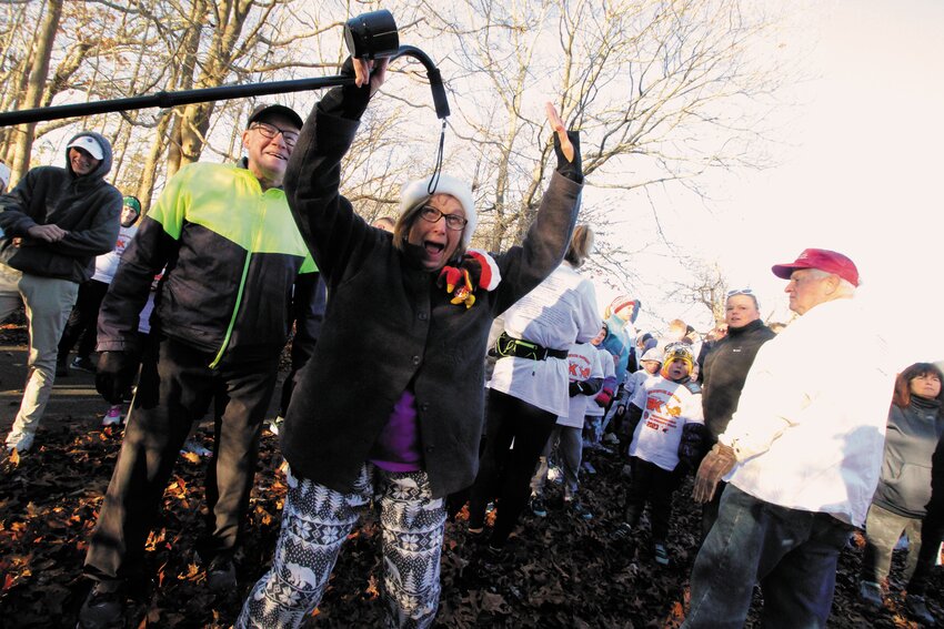 NO STOPPING HER: John and Heather Lynch were up early Thanksgiving morning as were more than 500 runners and walkers for the 10th annual Warwick Rotary Club turkey trot at City Park. Heather, who uses a cane, not only completed the course but also participated, as seen here, in the warm up calisthenics.   (Warwick Beacon photos)