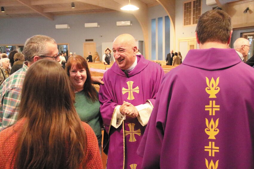 GREETING PARISHIONERS: Following the Mass, Fr. Marciano walked through the sanctuary, which quickly emptied for the church hall for a spread of sandwiches and baked goodies.