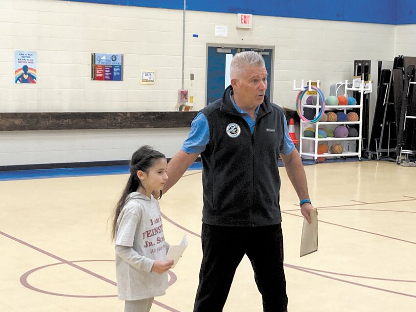 TALKING TO THE CROWD: Hoxsie principal Gary McCoombs encourages Sofiah Kidd to give her speech to the gathered crowd of first graders.