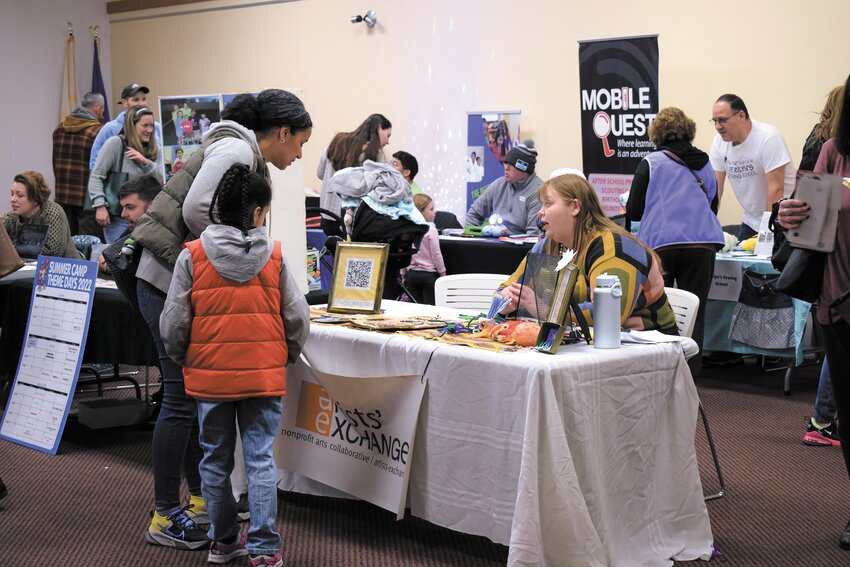 FIGURING IT OUT: A couple curious artists speak with a representative from the Artists&rsquo; Exchange about the possibility of signing up for camp. (Photo provided by Cranston Public Library)