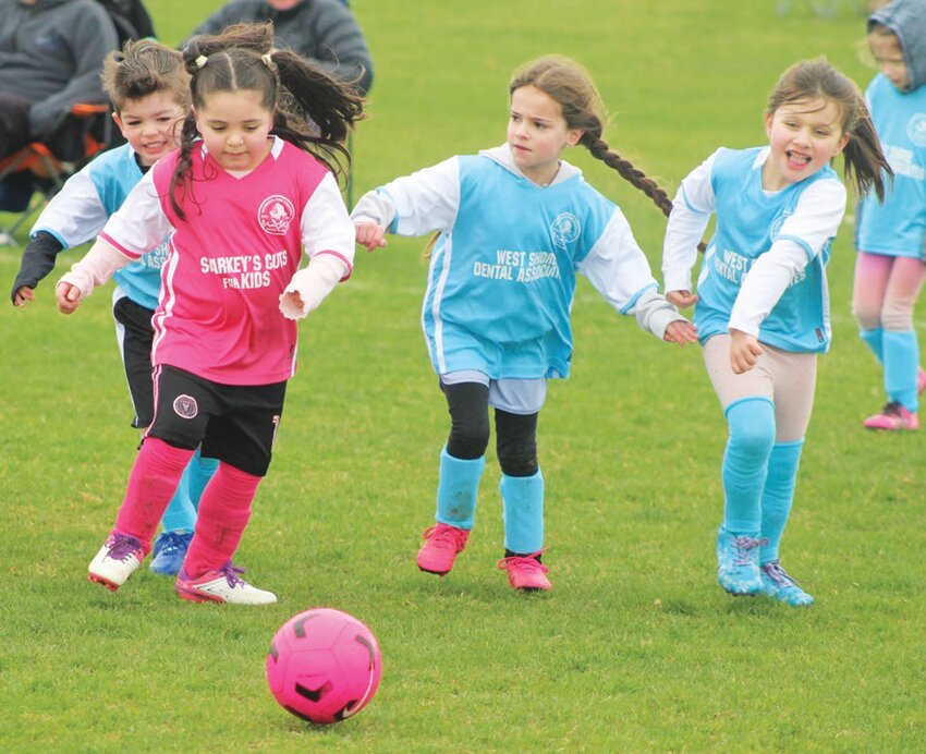 ON THE RUN: Orian Hathaway, Amelia Brodeur, Mya Gomes chase down Milena Hagopian as she dribbles the ball.