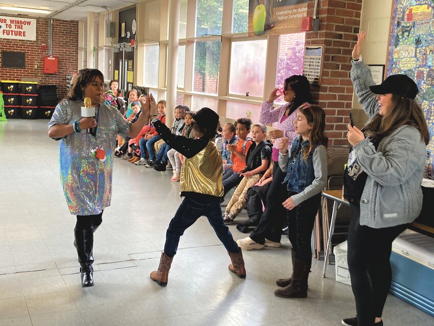 SUPERSTAR TREATMENT: Teacher assistant Jessica De Los Santos gets a high-five from a student as she walks past the DJ table to receive her recognition.