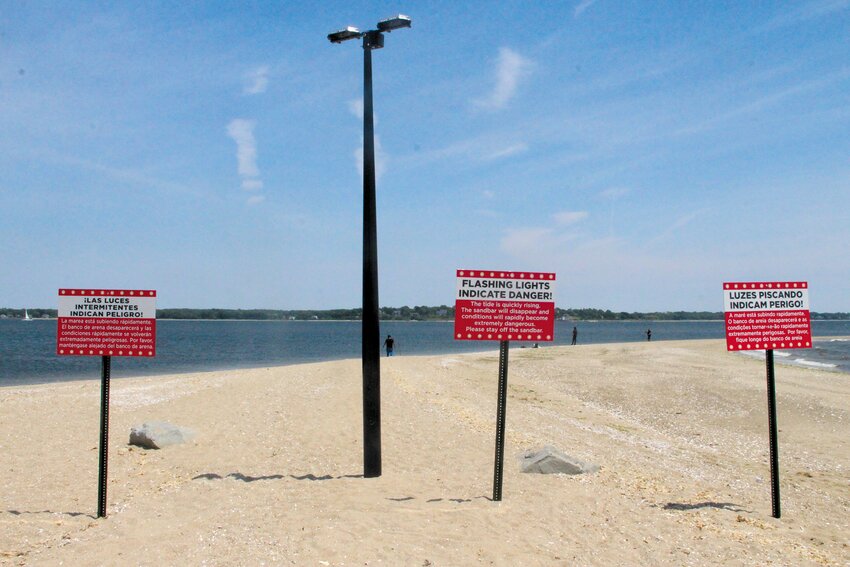 SOUNDS AND SIGNS: Warning signs alert Cominicut Point beachgoers of the sandbar&rsquo;s danger in three languages: English, Spanish and Portuguese.