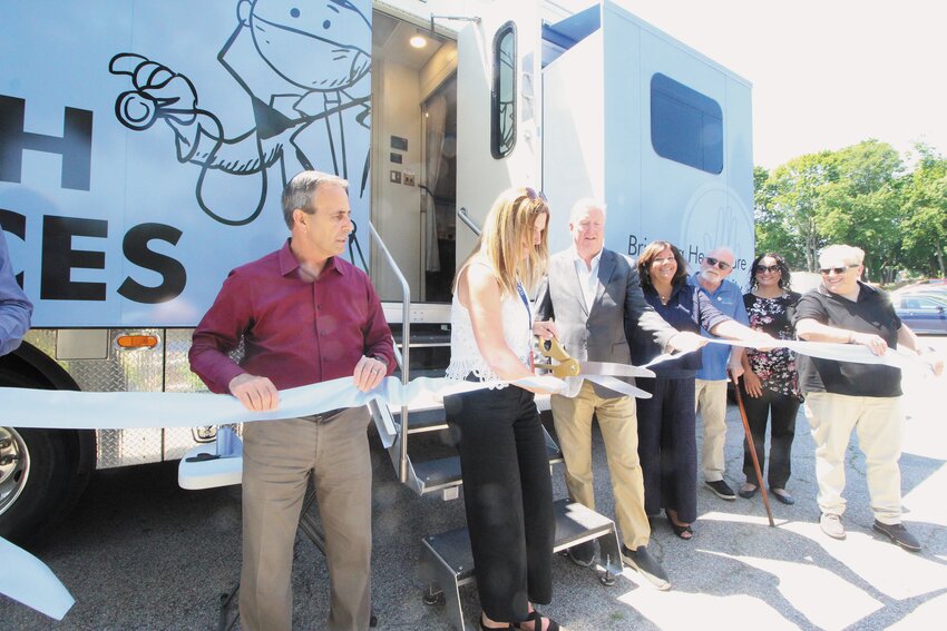 OFFICIALLY OPENED: Pratt, flanked by both mayors, cuts the ribbon, officially inaugurating CCAP&rsquo;s Mobile Medical Unit.