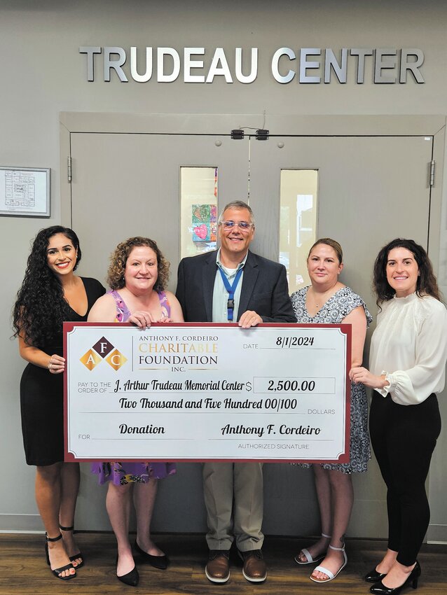 GIANT CHECK: Members of the Cordeiro family visited the Trudeau Center last week to present the check in person. Merrill Cordeiro, Sandy Peltier (director of Home and Center Based Children&rsquo;s Services), Al Vario (president &amp; CEO of Trudeau), Kelly Charlebois (vice president of advancement), and Melanie Cordeiro (left to right) pose with the giant check (Photo courtesy of Trudeau Center).