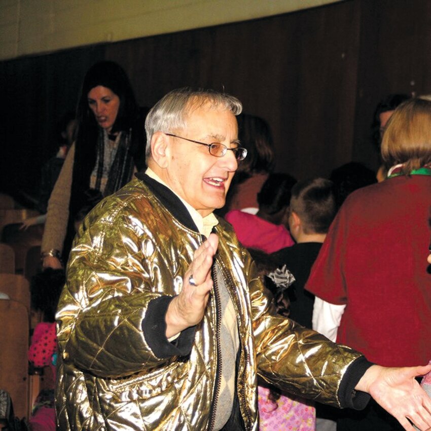 A HIT WITH KIDS: Clad in his gold jacket, Alan Shawn Feinstein addresses Aldrich Junior High students in this photo from 2014. Feinstein, who urged thousands of students to do good deeds and rewarded them for doing so and whose name is on so many schools throughout the state, died Saturday at the age of 93. He lived in a modest home in the Edgewood section of Cranston.