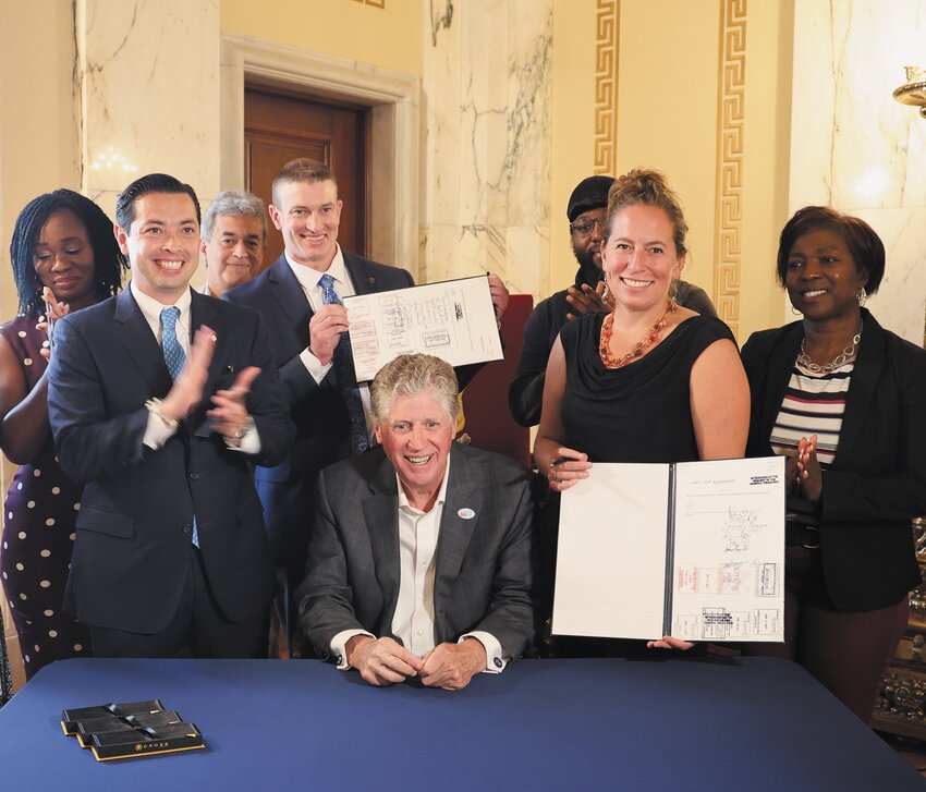 MAKING IT HAPPEN: Rep. Evan Shanley of Warwick and East Greenwich and Sen. Meghan Kallman (D-Dist. 15) hold up copies of the Secure Choice bill that they co-sponsored when signed last Thursday by Gov. McKee. (Submitted photo)