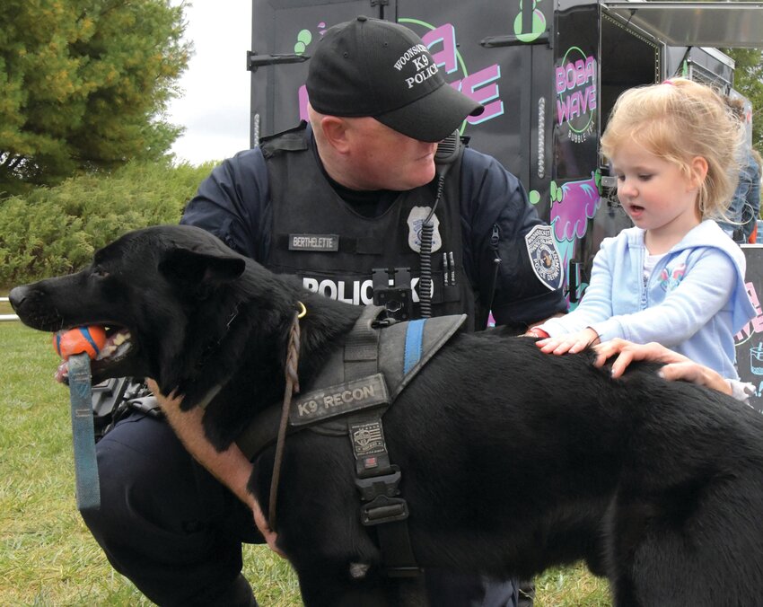 K9 EXPERIENCE: Under the watchful eye of K-9 officers, youngsters got to meet (and pet) police dogs.  Here, Officer Jason  Berthelette from the Woonsocket Police Department was happy to bring his dog, Recon, to the Cranston event. (Cranston Herald photos by Barbara Polichetti)