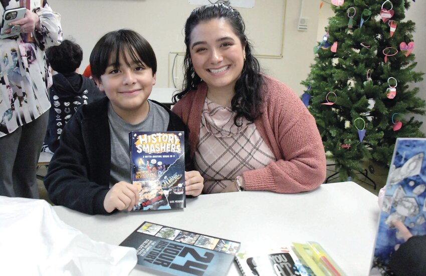 Mirna Gutierrez and her son, Sebastian, look at his new books. (Beacon Media photos by Barbara Polichetti)
