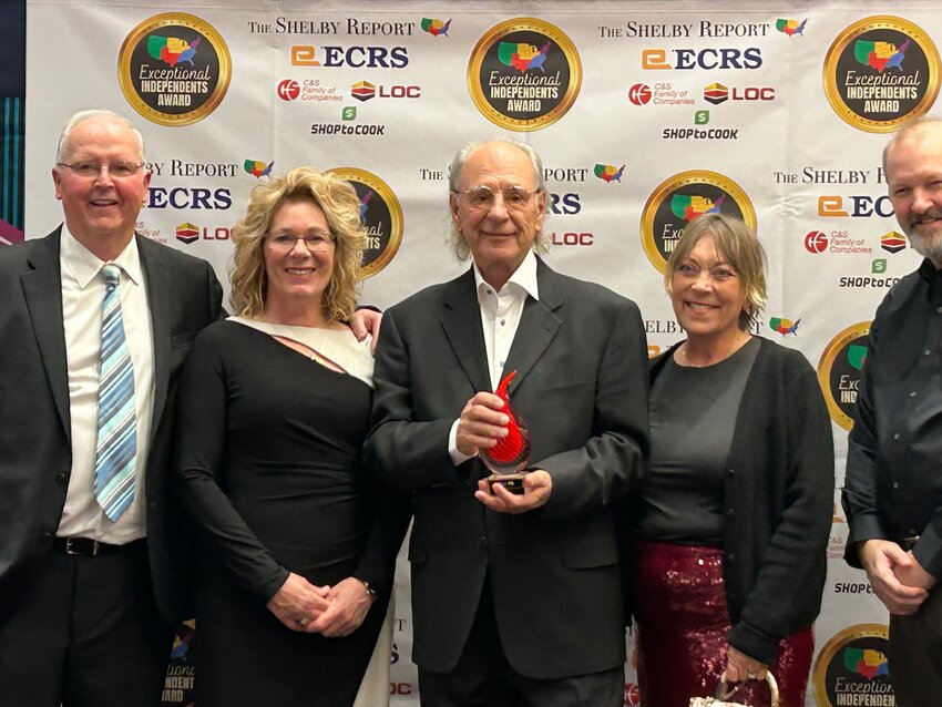 Dave Cesario (center), surrounded by friends and family, holds the IGA’s International Retailer of the Year trophy.