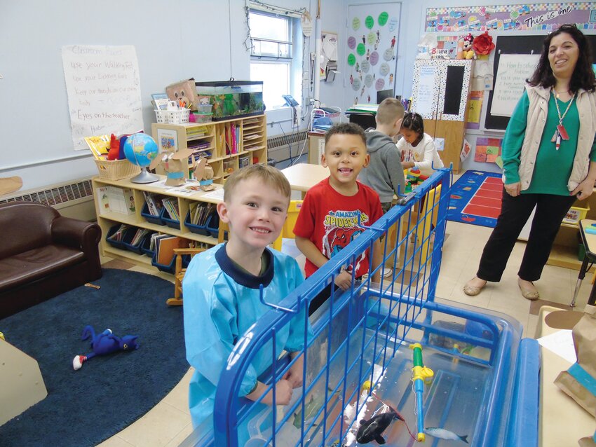 Hudson and Benjamin play together at the aquatic station with toy sharks as part of this month’s activity: a pet study in which students in class learn about different animals.