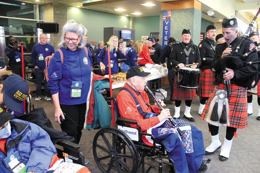 WWII veteran Wilfred Barbeau, who will celebrate his 100th birthday this month, took out his clarinet and played along with bagpiper Allen Manley and the rest of the bagpipers who joined in at a Southwest Airlines departure gate at Rhode Island T.F. Green International Airport early Sunday.