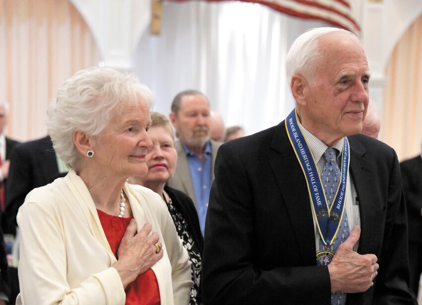 Howell and his wife, Carol, salute the flag during the induction ceremony.