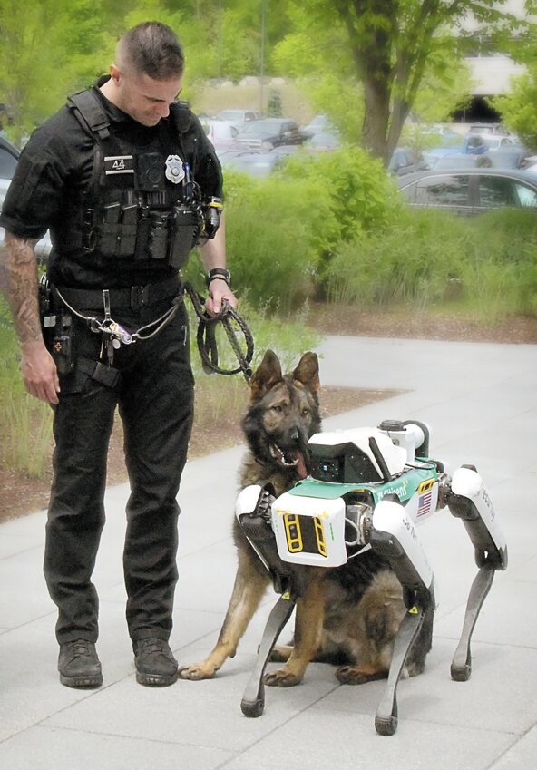 Johnston police dog Honza, with  K-9 patrol officer Eli McGuire-Kruege, checks out his robotic counterpart at the Citizens Bank corporate campus in town.