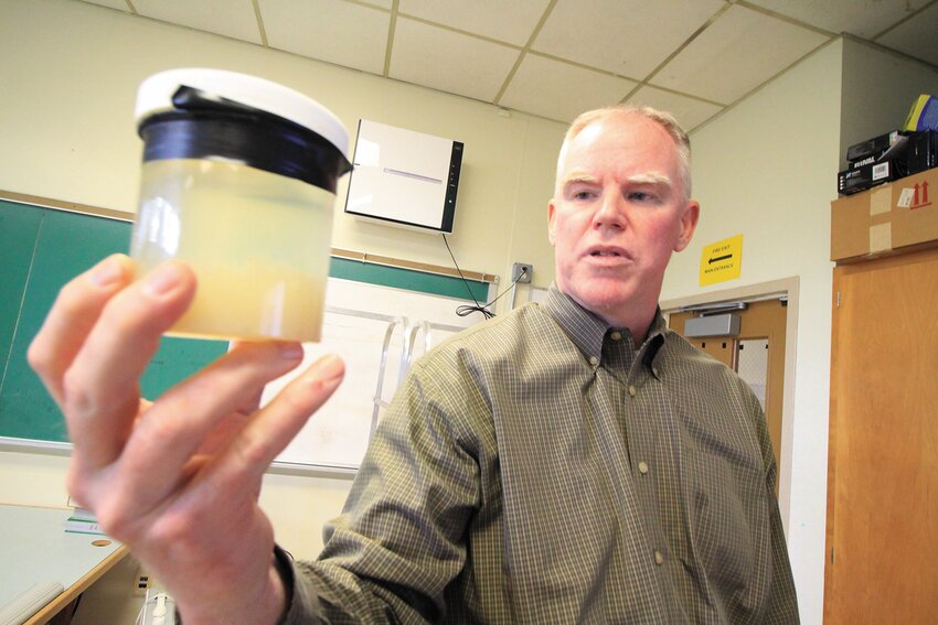Pilgrim science teacher Gregory Rowe holds up a sample of water containing phytoplankton he gathered on a trip aboard the URI research vessel Endeavor.