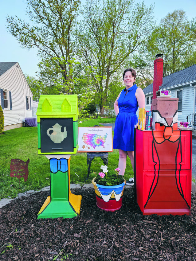 Katie Frazier at the Little Free Library in front of her home in Warwick.