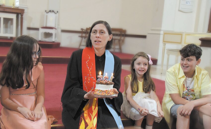 The Rev. Amy Chilton, pastor at Phillips Memorial Church, shares a birthday cake with young congregants at a special service this month as the Eden Park Church celebrates its 125th anniversary year.
