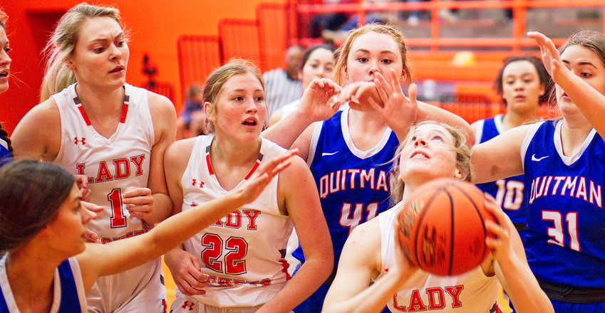 Mylee Fischer of Mineola looks to put up a shot after rebounding, surrounded by eight of the nine players on the floor.