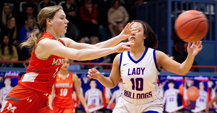 Lady Jacket Mylee Fischer passes the ball from the top of the key by Lady Bulldog defender Ashley Davis.