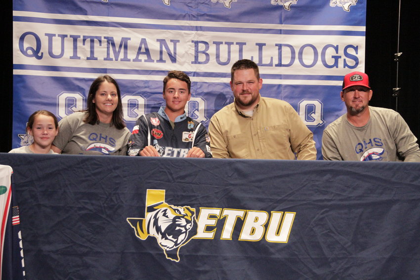 Haydan Marshall of Quitman (center) signed his letter of intent to join the fishing team at East Texas Baptist University April 12. From left are his sister Cayslyn, mom Caysi, ETBU coach Cameron Burger and dad Harlan.