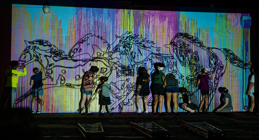Participants trace the outline for the mural as projected onto the wall.
