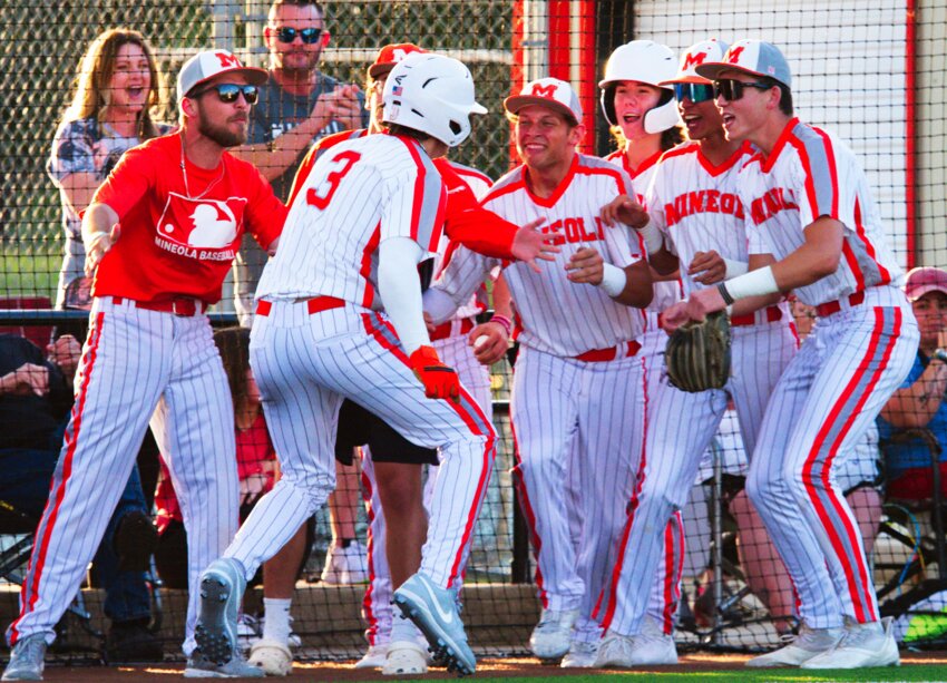 The Yellowjackets welcome Brady Shrum back to the dugout after scoring Mineola's first run.