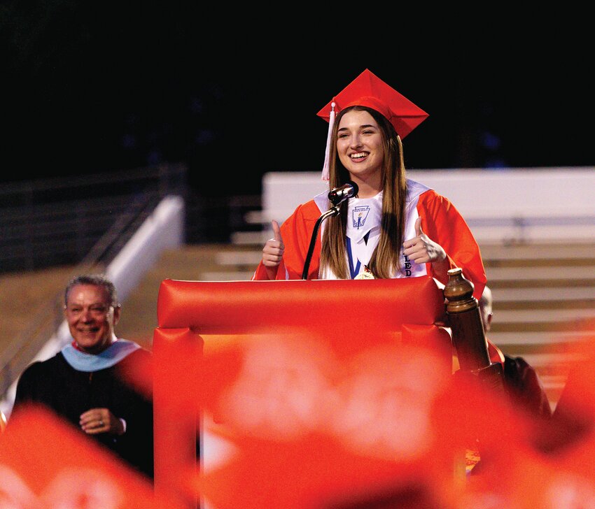 Mineola High School valedictorian Ali Jordan checks the sound as she begins her speech at graduation.