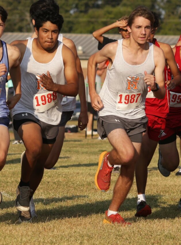 Mineola runners Javier Sanchez, left, and Grayson Potts stride off of the starting line at the Yellowjacket Invitational cross country meet Friday.