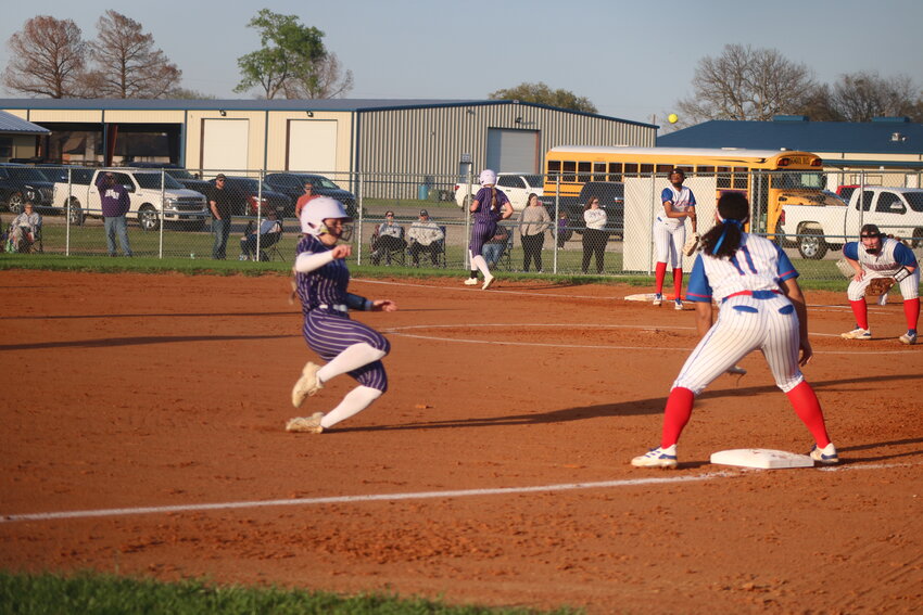 Lady Bulldog Allie Berry throws to Ashley Davis for an out at 3rd while pitcher Kennedi Elmore looks on.