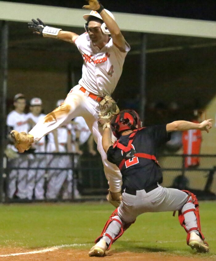 Matthew Ballew goes airborne in an effort to avoid a Red Devil tag at the plate. The Jackets defeated Chapel Hill, 11-6, to begin district play 2-0.