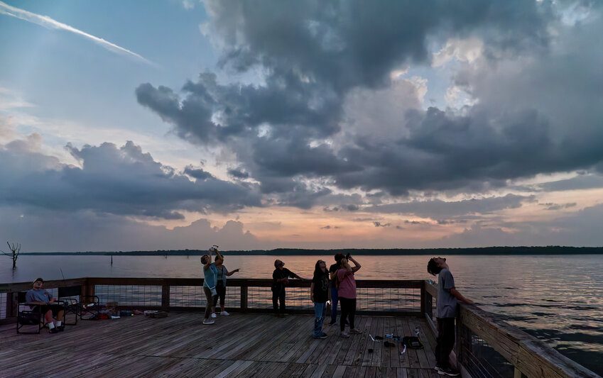 Onlookers at Swearingen Park on Lake Fork observe the total solar eclipse, as the horizon appears as though the sun were setting in all directions &ndash; here, north &ndash; despite being midday.