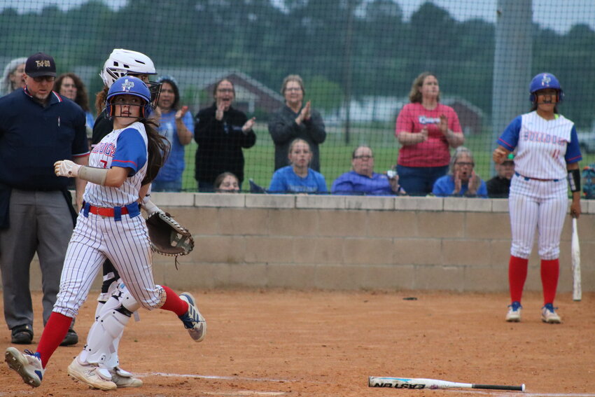 Addison Marcee crossing home plate with Ashley Davis in the background cheering.