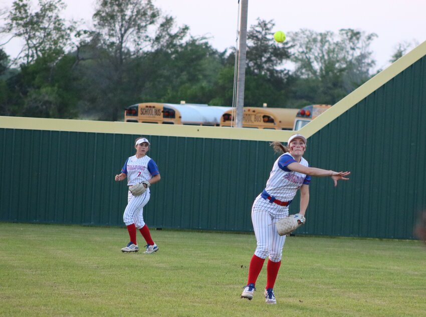Hannah Holland of Quitman throws home while Addison Marcee looks on.