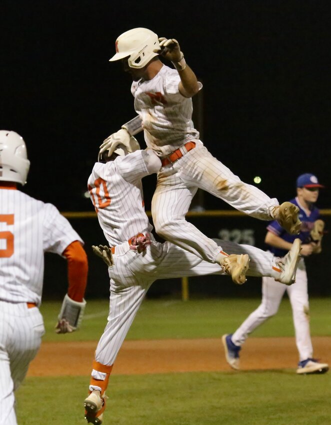 Matthew Ballew leaps over teammate Preston Haskin after cracking the walk-off base hit.