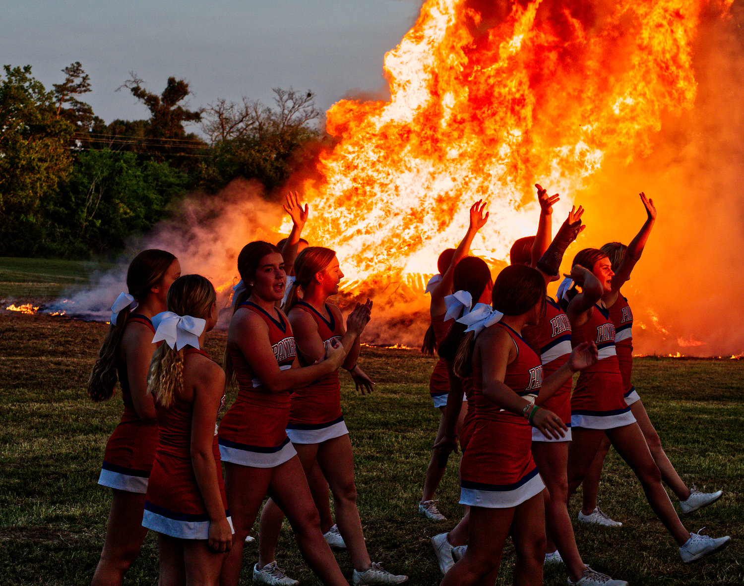 Alba-Golden High School cheerleaders pep up the crowd at the homecoming bonfire held last Wednesday night near the school.